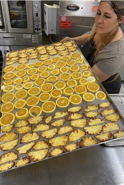 lady holding a tray with dried fruits
